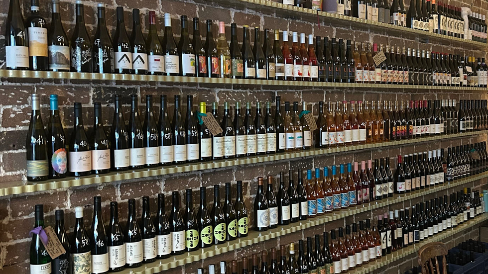 A brick wall lined with wine bottles