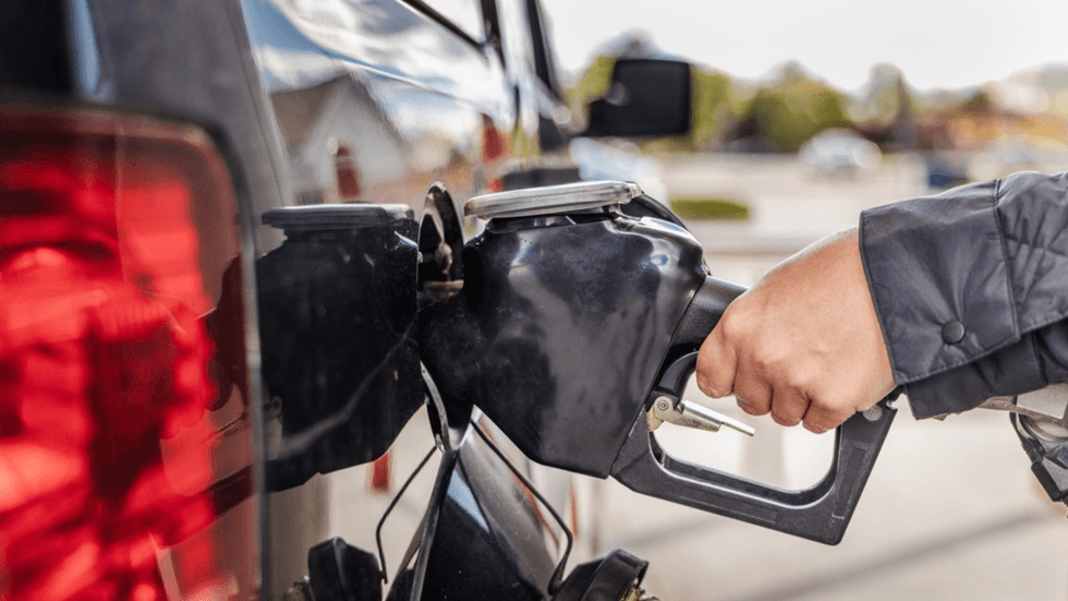 A close up of a hand filling up a car petrol tank