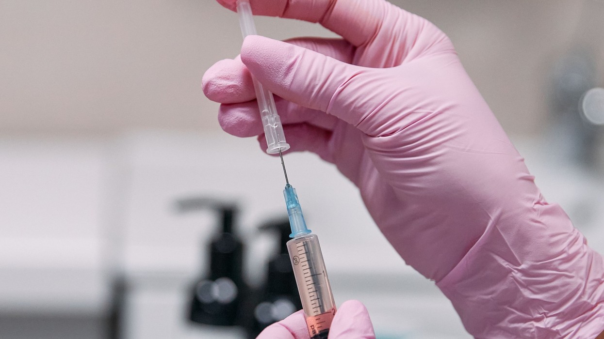 A close up of a hand holding a injection