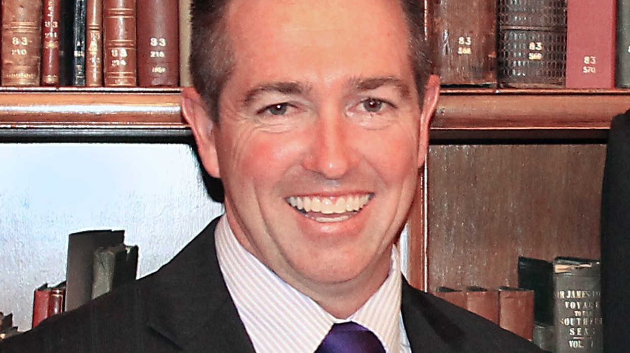 A close up of a man with brown hair smiling at the camera.