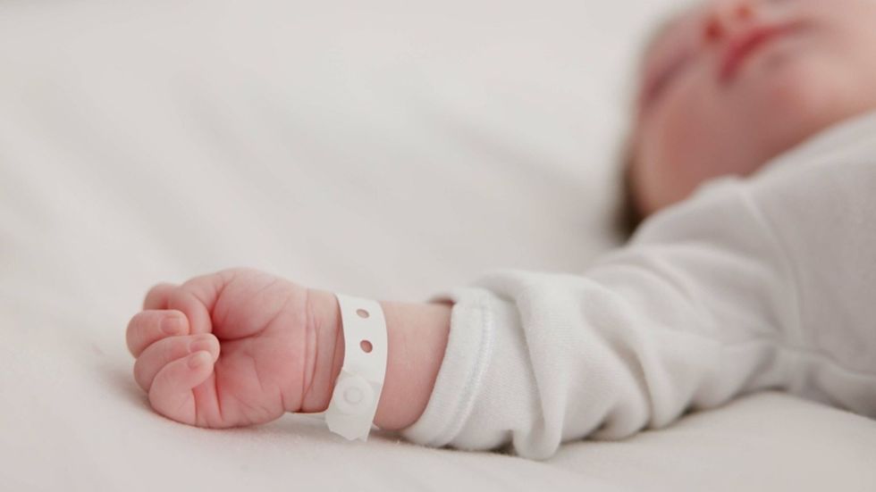 A close up of a small baby's outstretched hand