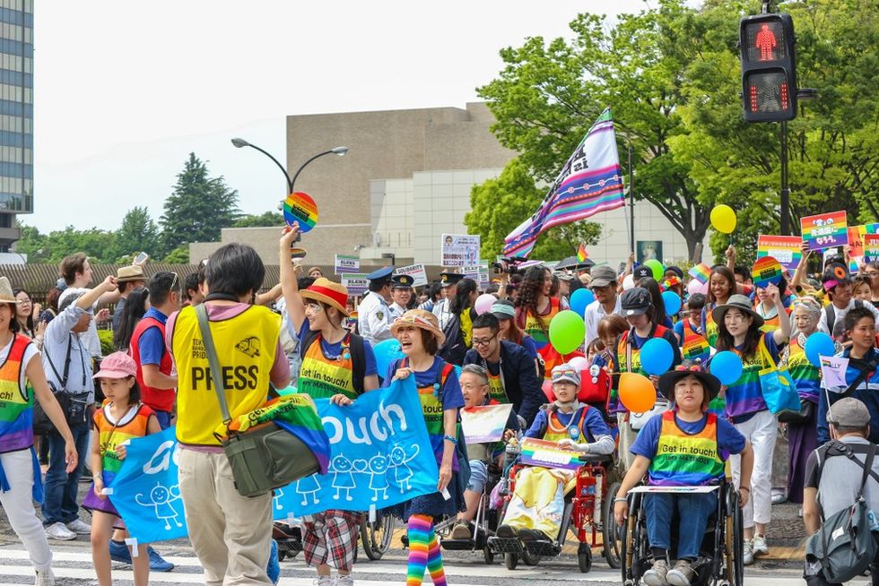 A crowd of people wearing rainbow outfits