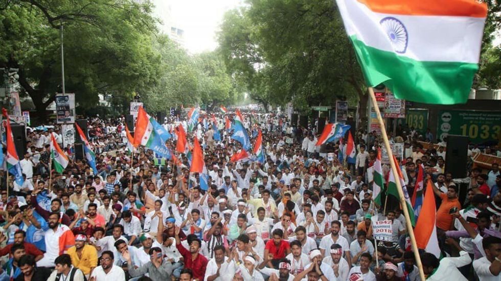 A crowd of young people waving Indian flags