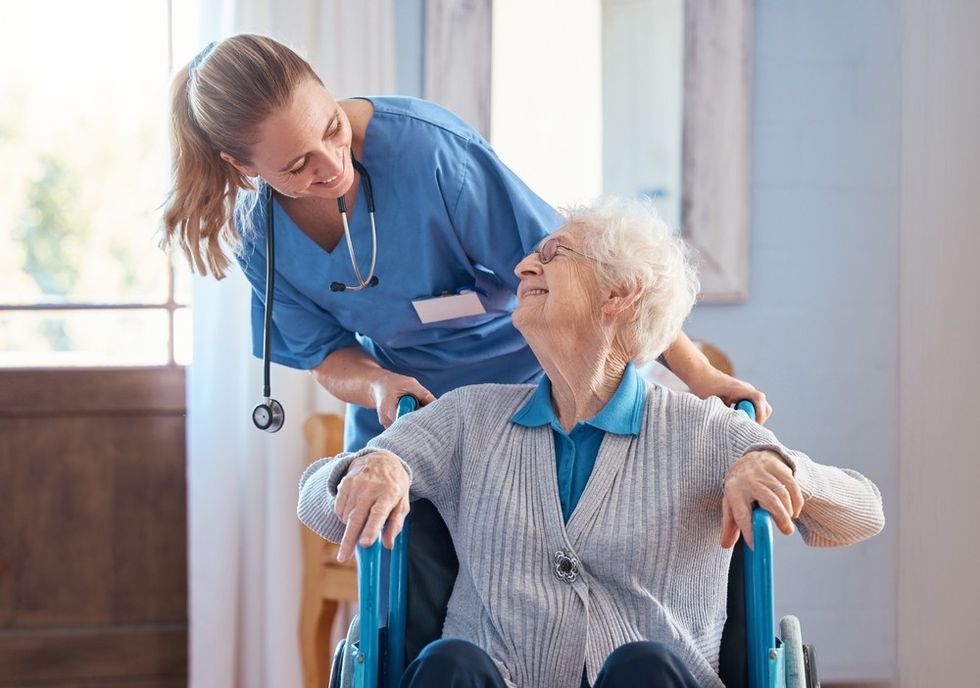 A female nurse with an elderly woman in a wheelchair