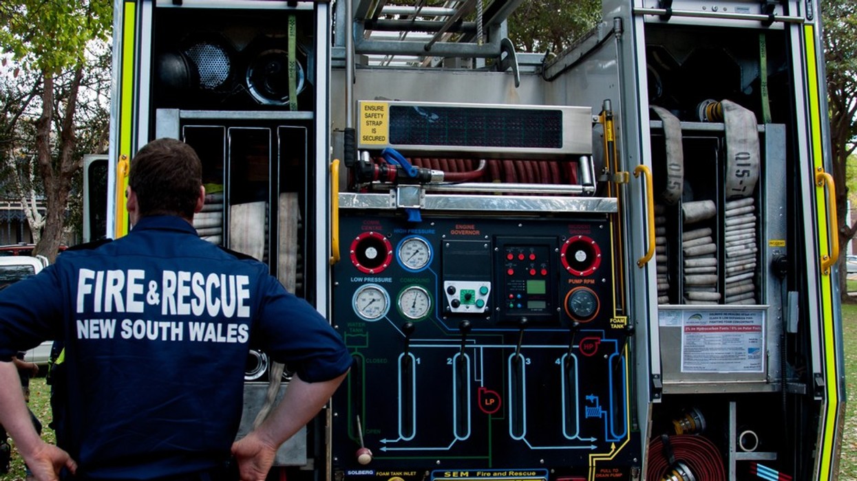 A fire rescue worker behind a fire truck