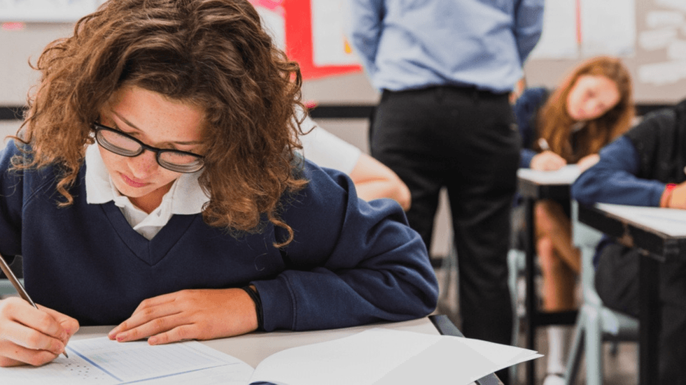A girl in a classroom filling out a form