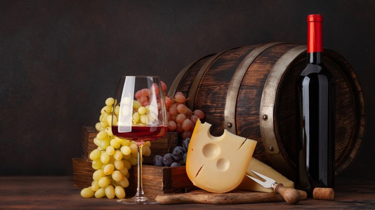 A glass of wine against a cheese board.
