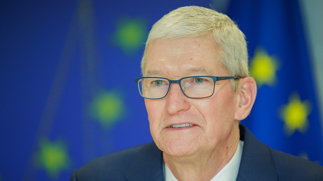 A grey haired man wearing glasses