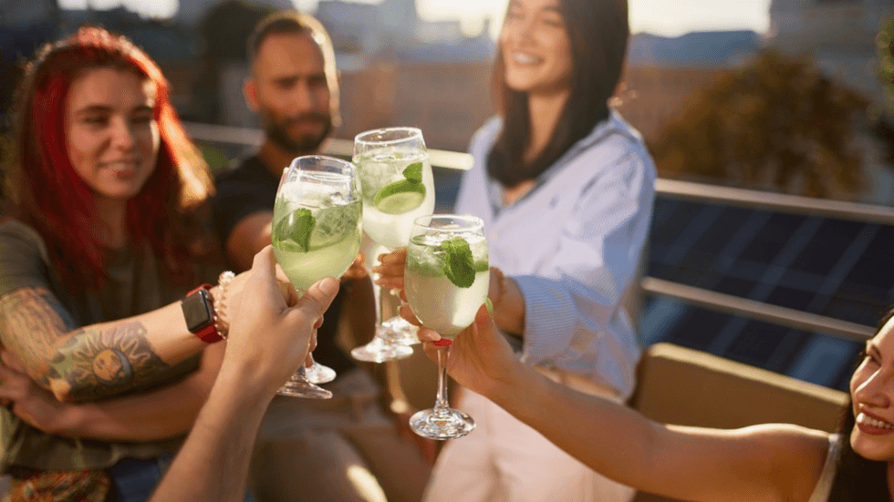 A group of young women clinking glasses of alcohol-free drinks