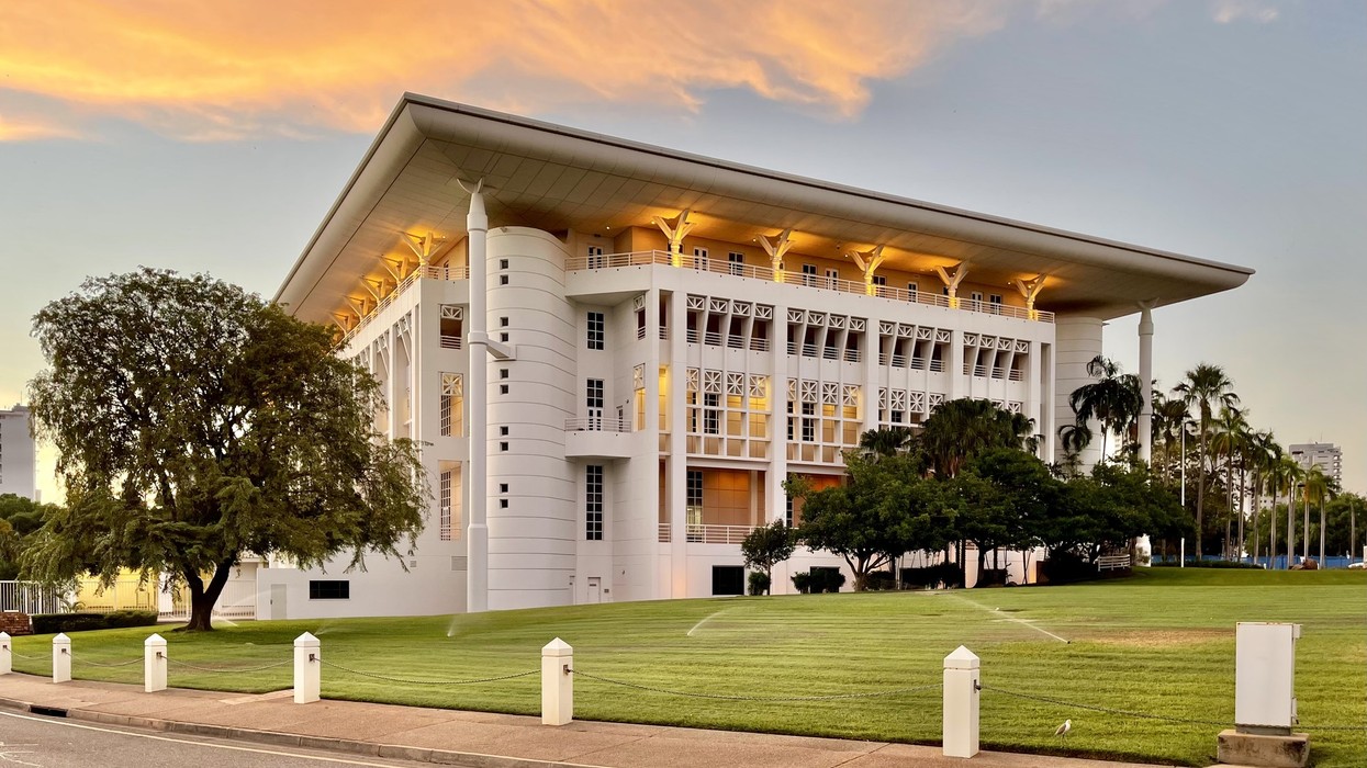 A large parliamentary building on green lawns