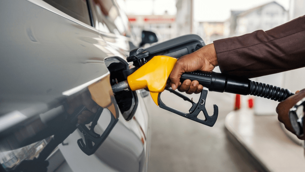 A male hand putting petrol into a car