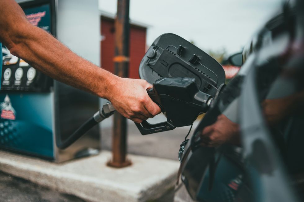 A male hand putting petrol into the tank of a car