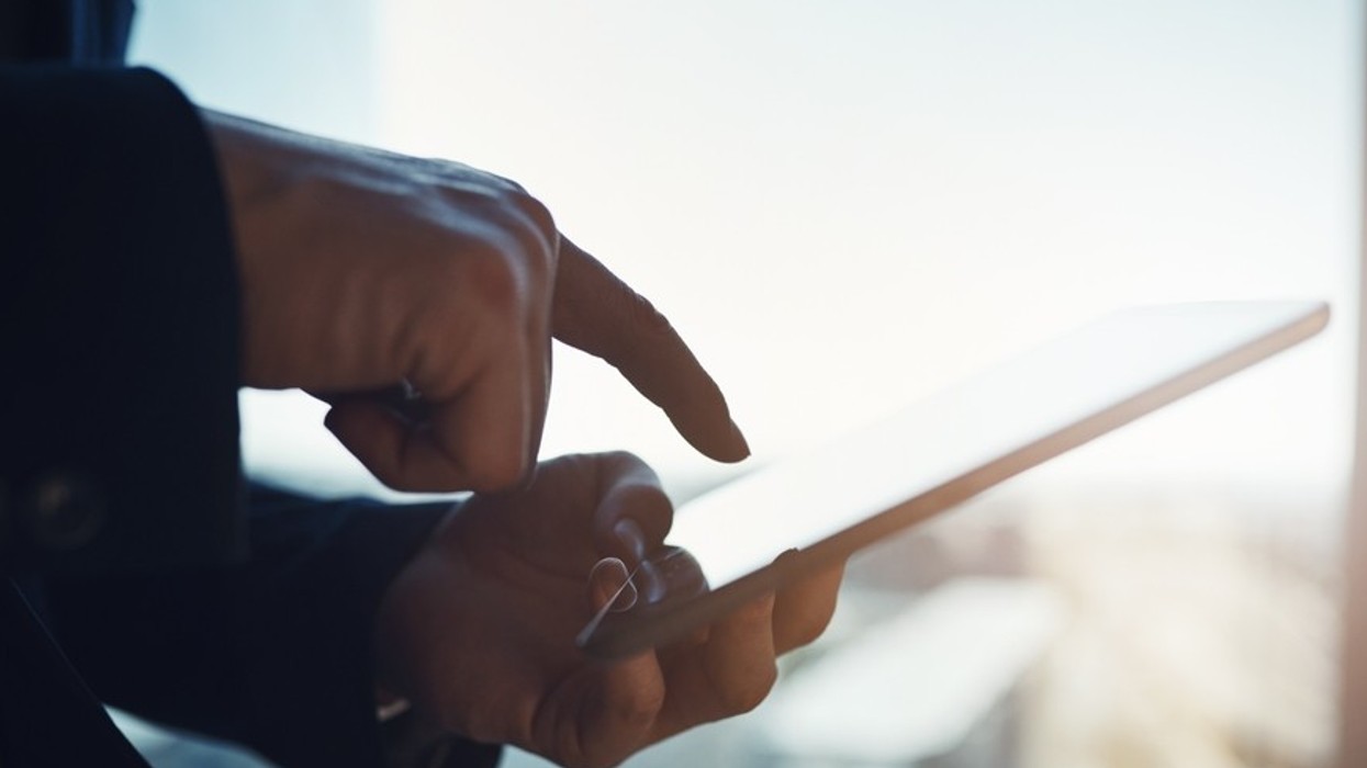 A man holds a phone as if to click on something