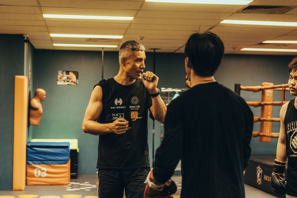 A man paused before boxing with a training partner at a gym