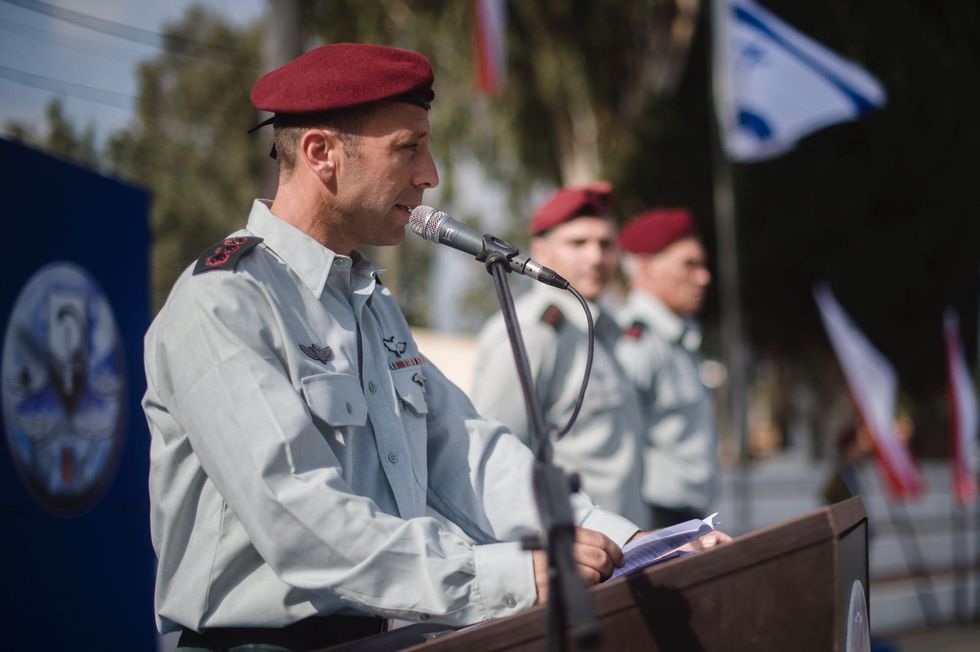 A man wearing a red beret speaking at a podium