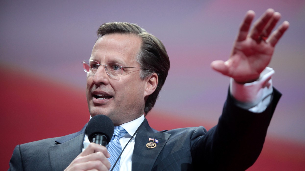 A man wearing rimless glasses with a microphone