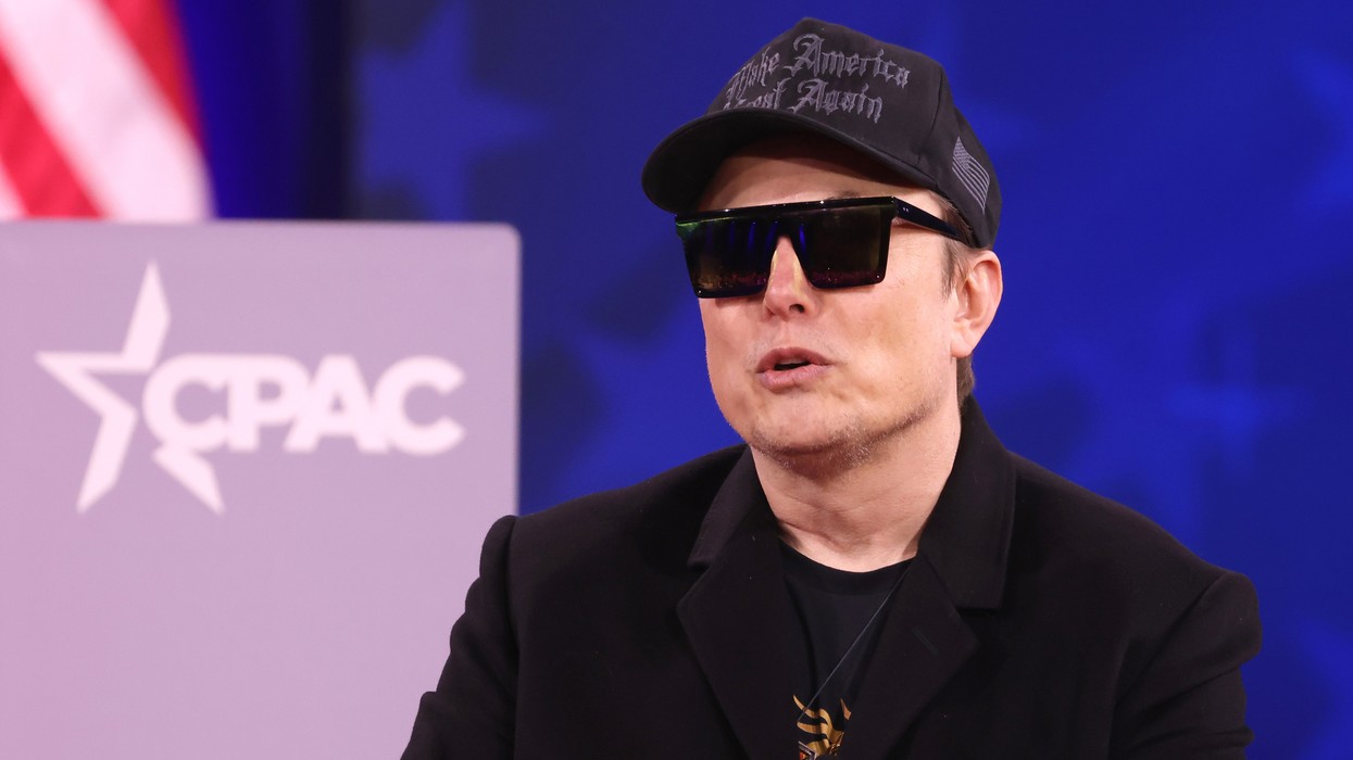 A man wearing sunglasses and a cap inside at a convention