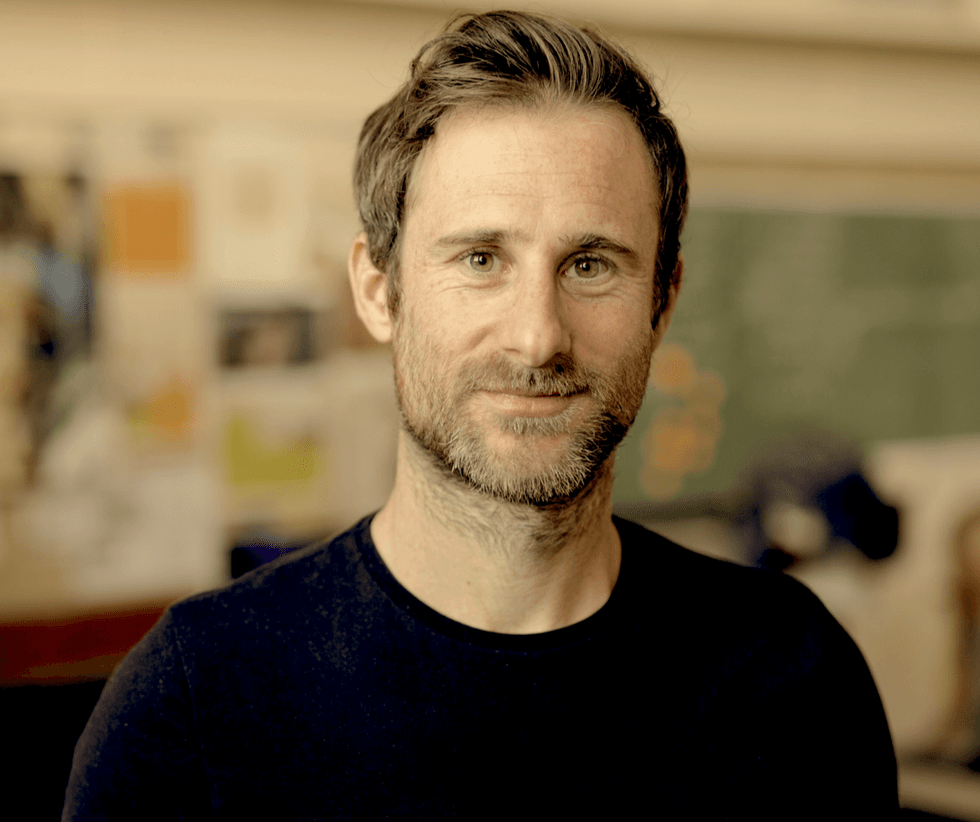 A man with green eyes smiles at the camera