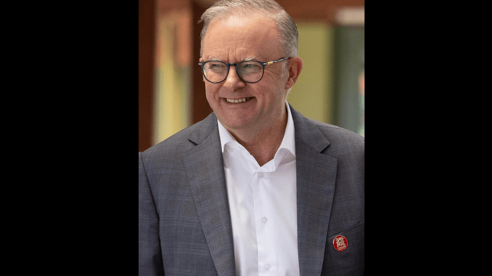 A middle aged man wearing glasses with an suit and open necked shirt