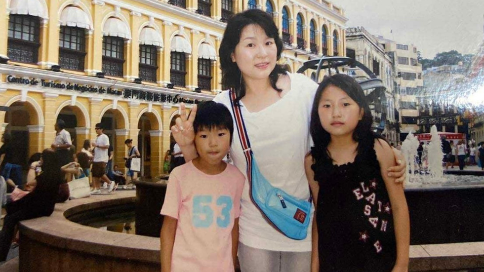 A mother and her two children smile at the camera