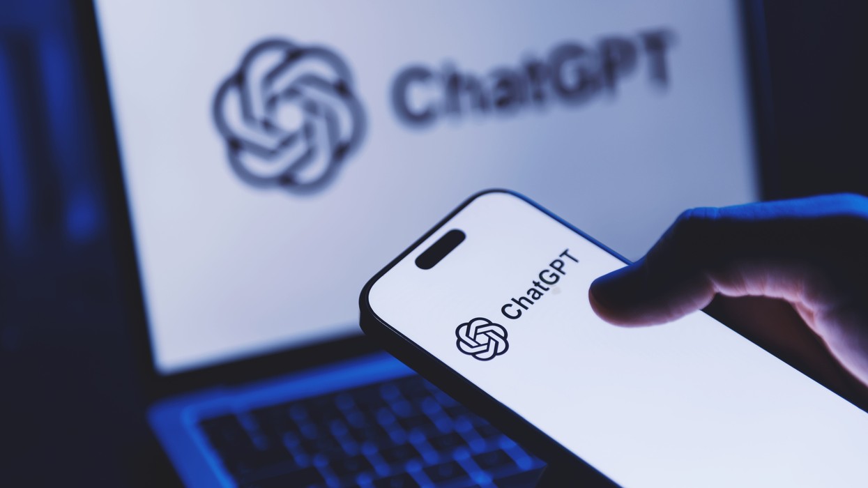A phone showing the ChatGPT logo against a laptop showing the same logo