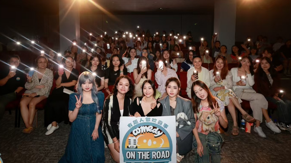 A photo of a large audience, mostly women, smiles at the camera