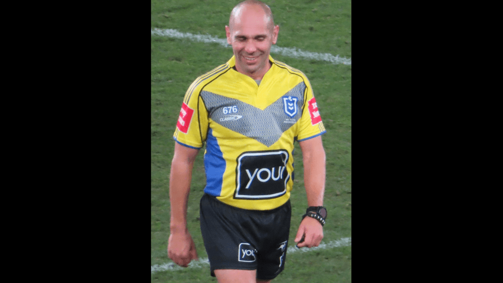 A referee in a yellow t-shirt on the field