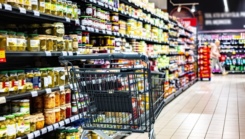 A supermarket trolley in an empty supermarket aisle