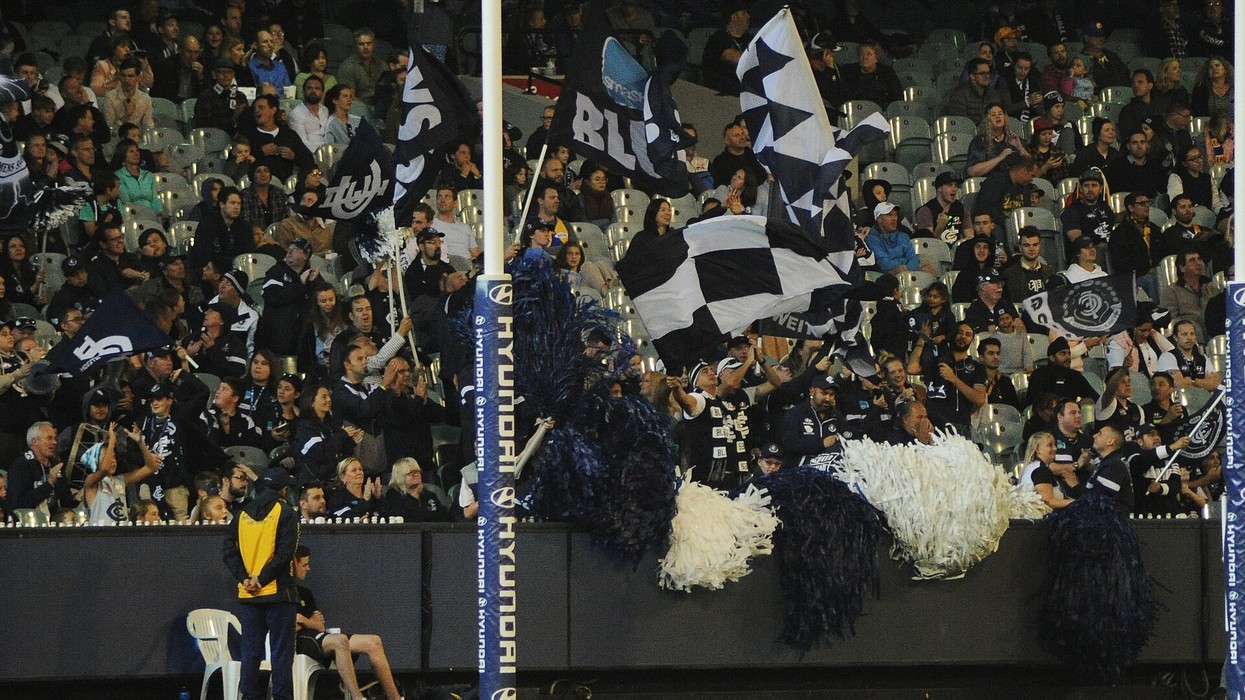 A view of the Carlton football crowd waving black and white flags