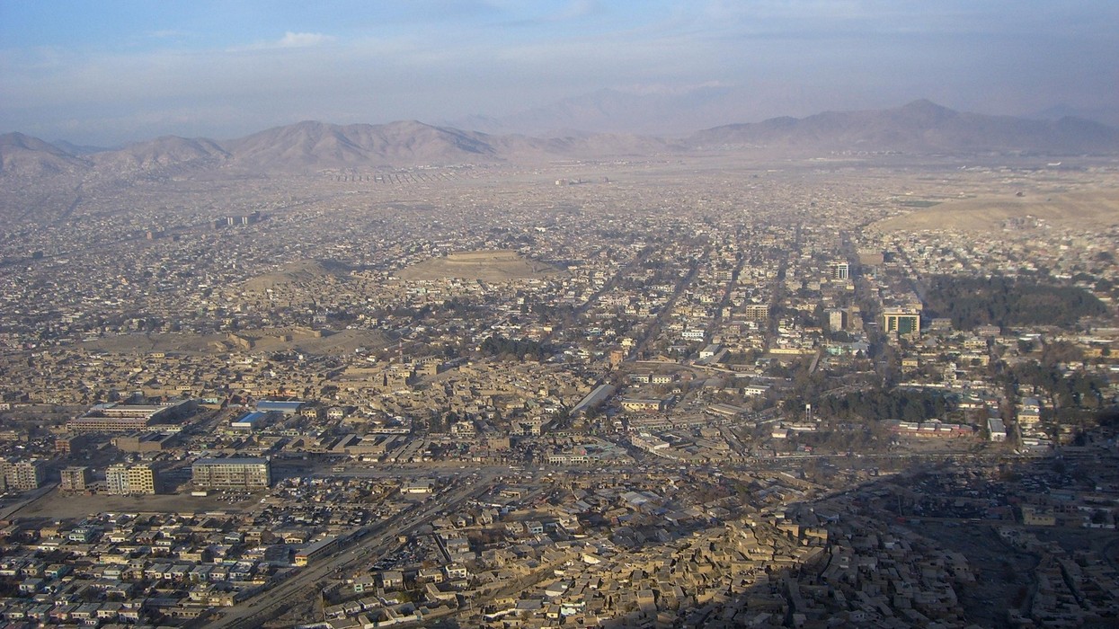 A wide shot of a city surrounded by mountains.