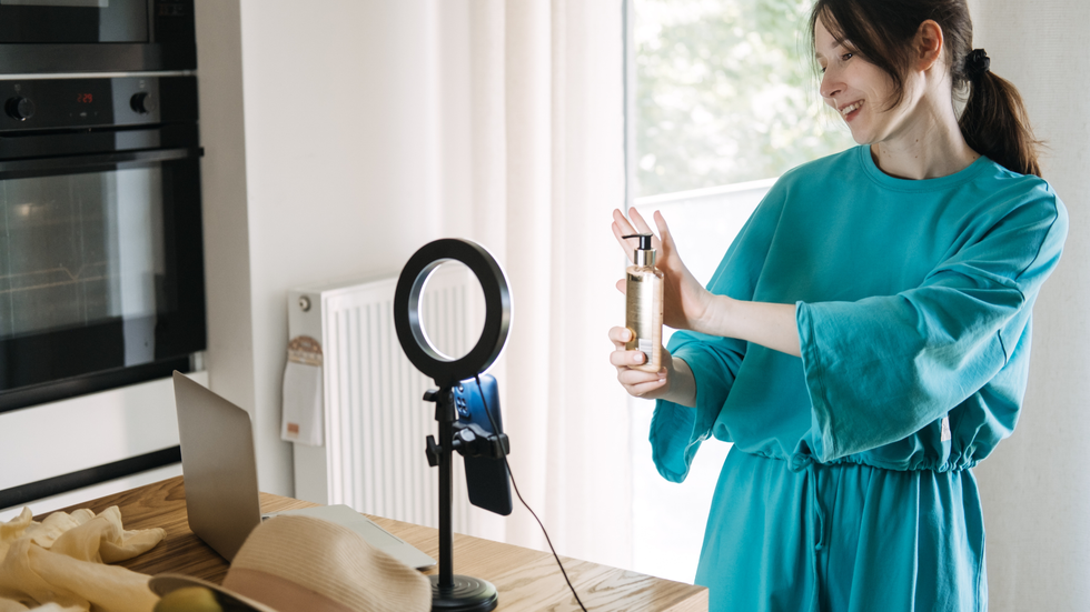A woman filming herself holding up a product