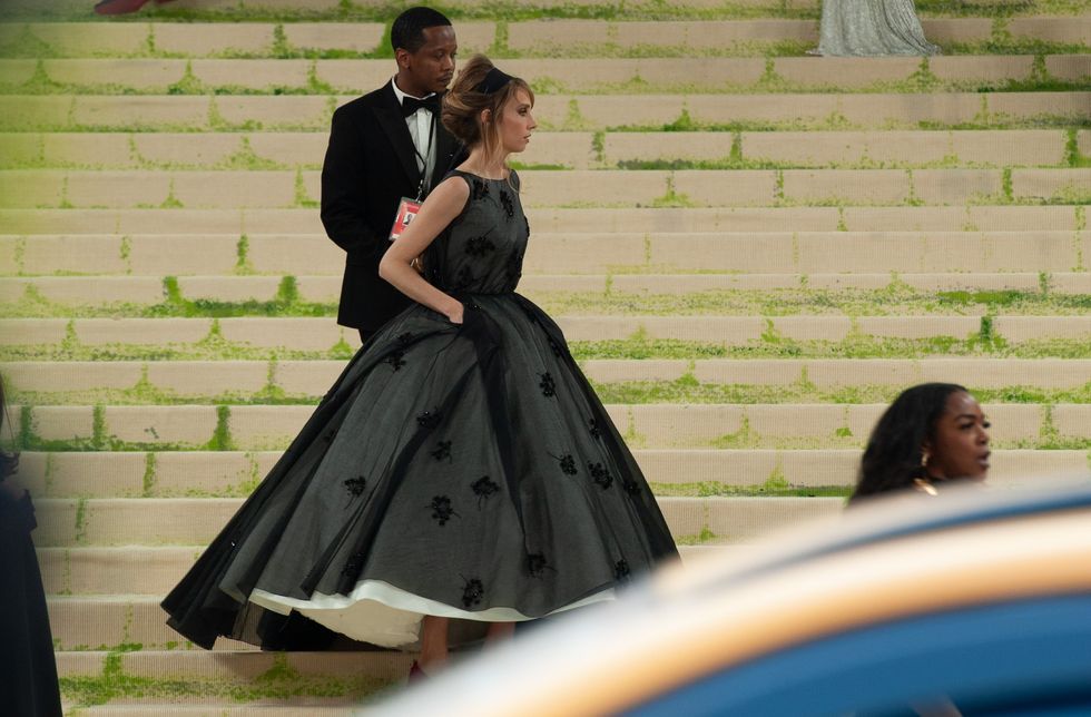 A woman in a black sleeveless dress with a very full skirt