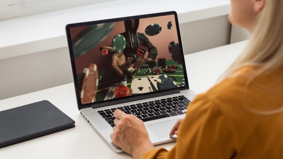 A woman looks at a laptop screen that shows an online casino