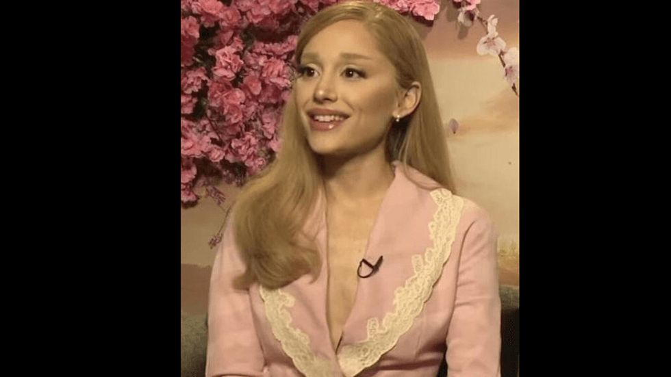 A woman with blond hair and a pink suit