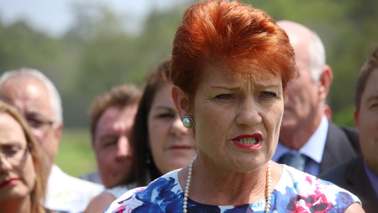 A woman with red hair speaks to a group of people