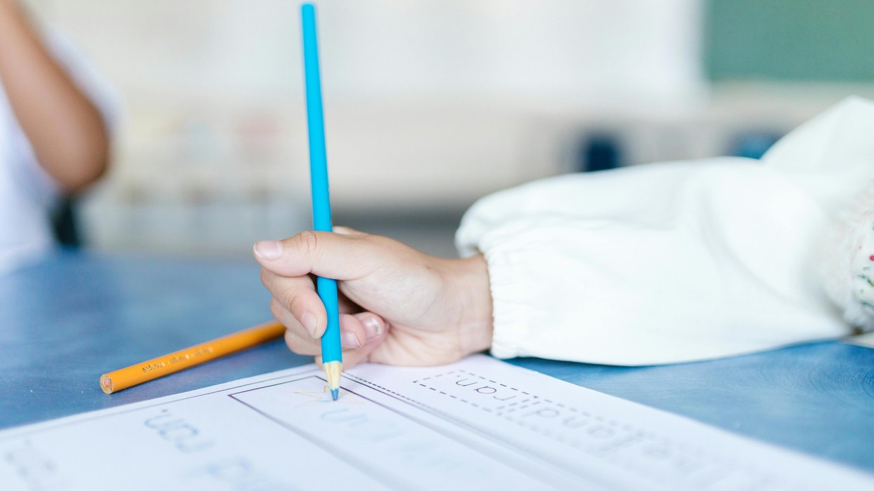 A young female hand holding a pencil