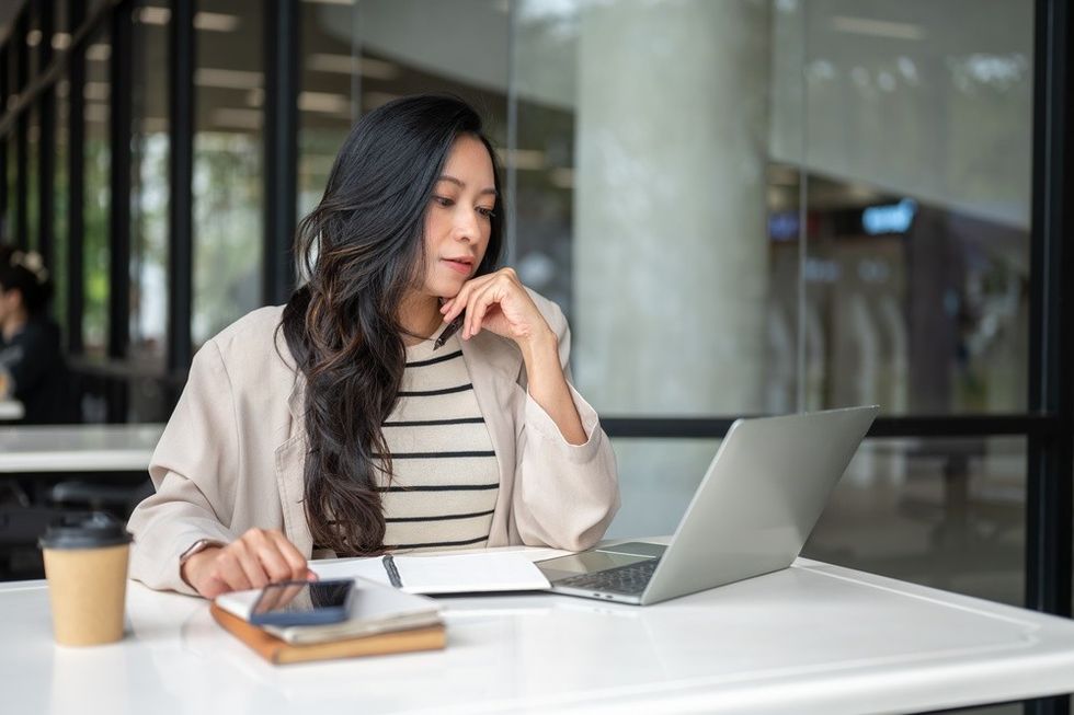 A young woman looking at a laptopI