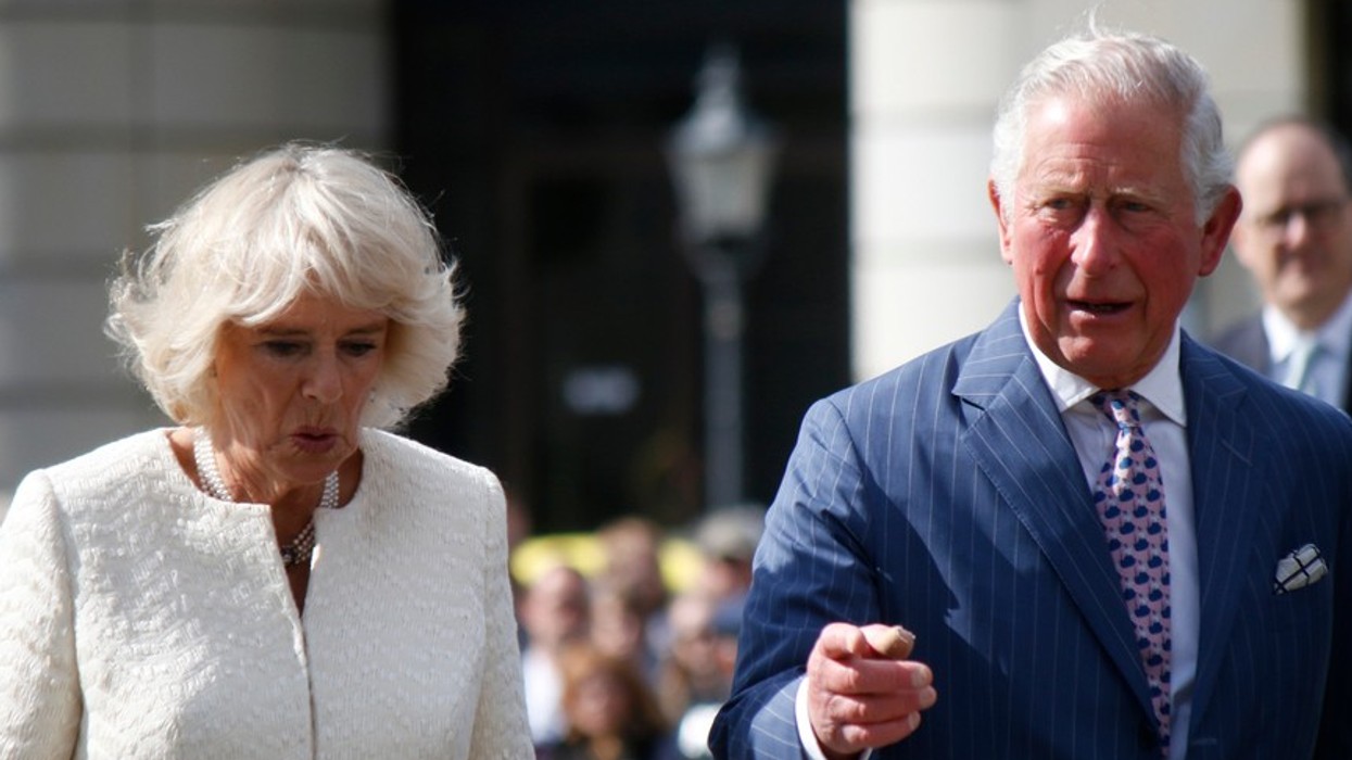 An elderly woman and man dressed in suits walking through the streets