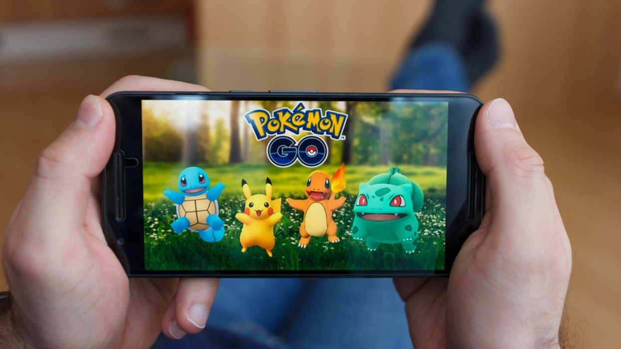 An image of Pokemon Go on a console held by a man.