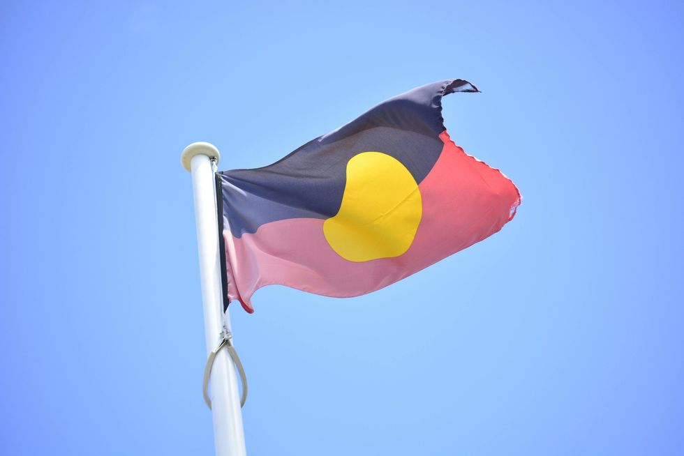An Indigenous flag flies on a mast