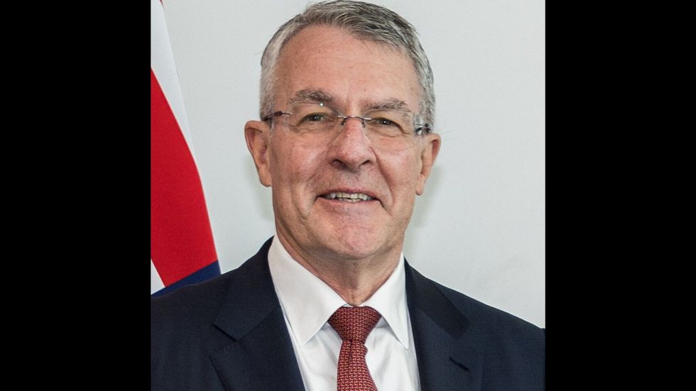 An older man in a suit with a red tie