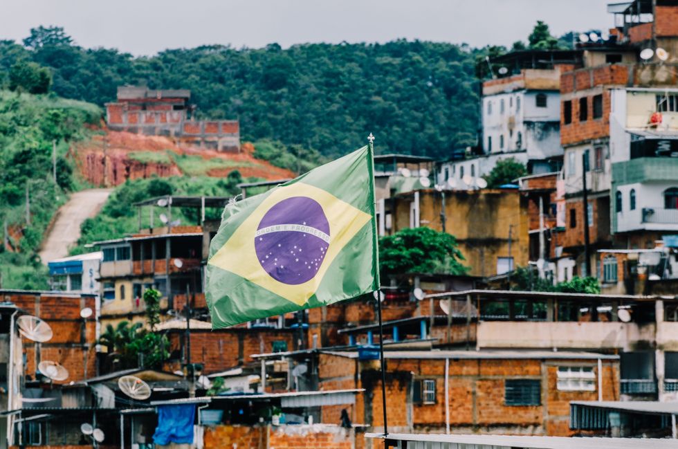 Brazil flag centred with a background of favelas