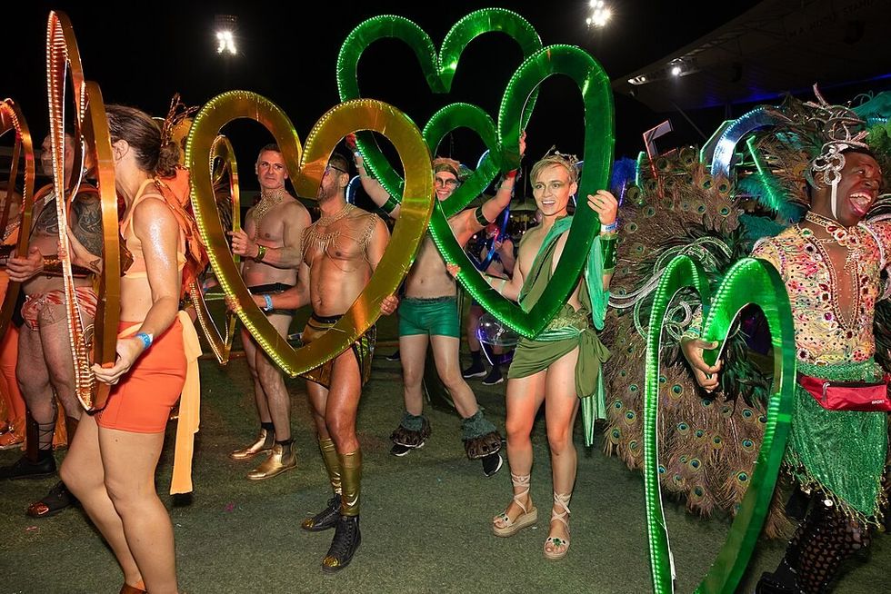 Colourful image of scantily clad people holding up perspex hearts