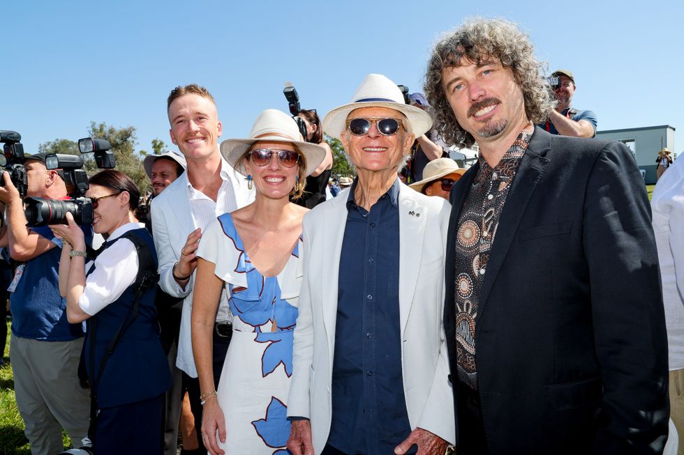 Four people out on a sunny day smile at camera