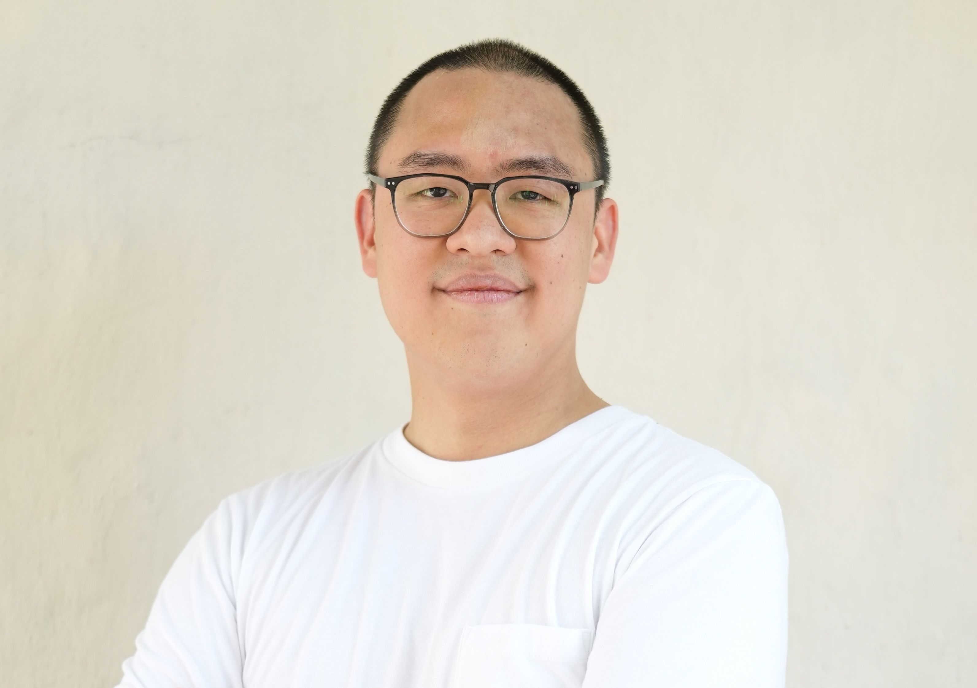 Head and shoulders image of a young man of Asian appearance in a white T-shirt.
