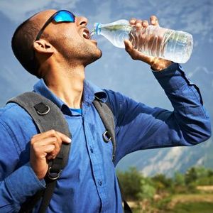 Image of Himalayan range lit with the sun's first rays. First inset shows a trekker drinking from a plastic water bottle, second inset shows litter in the Himalayas.