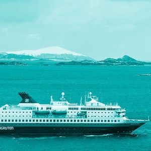 Image of tourist ship with Antarctica in the background.