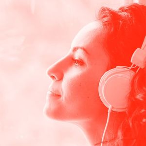 Woman wearing headphones staring off into the distance.