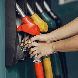 A man in a dark blue suit, a petrol bowser and a selection of cheeses.