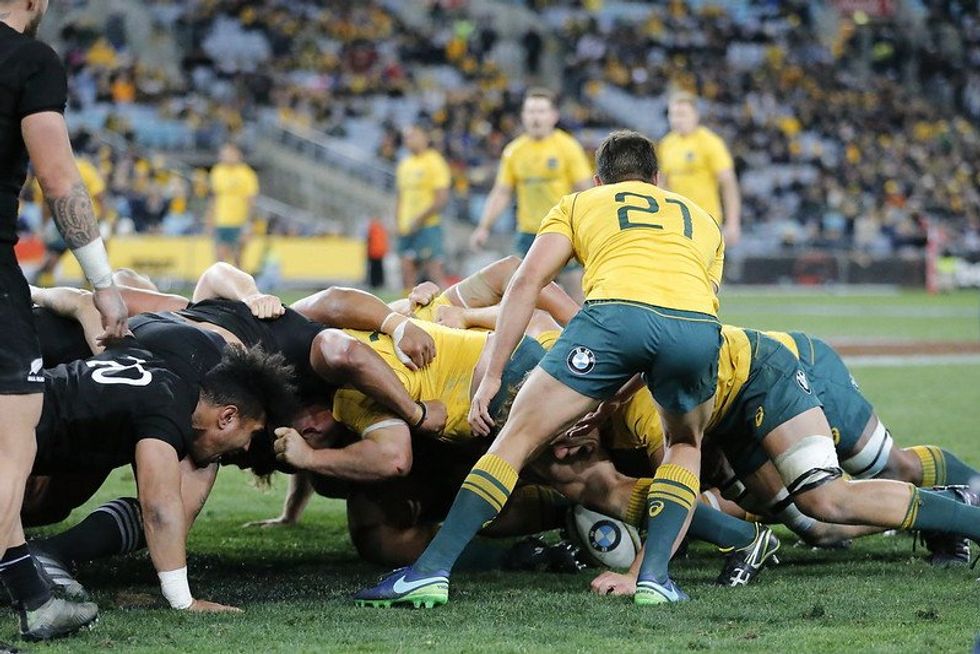Men packing down for a scrum in a game of rugby. 